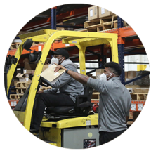 Warehouse workers driving a forklift